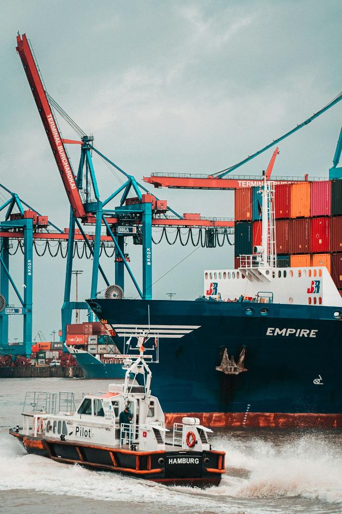 a tug boat in front of a large cargo ship